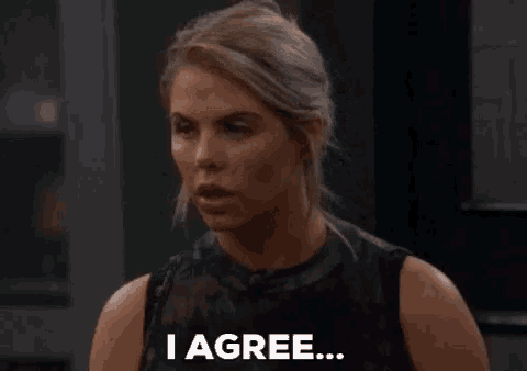 a woman is saying i agree in a dark room