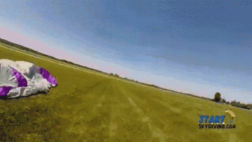 a purple and white parachute is in a field with the words start skydiving.com