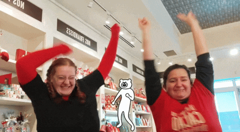 two women are raising their arms in the air in front of a sign that says " ice evaporated "