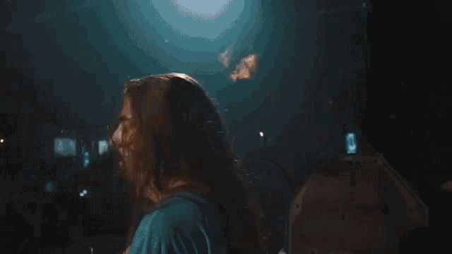 a person is playing a video game in a dark room with a fire coming out of the corner .