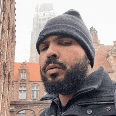 a man with a beard is wearing a beanie and a jacket