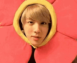 a man is wearing a flower hat on his head and making a funny face .