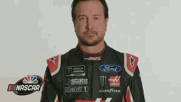 a man is wearing a nascar uniform with a ford logo on the front