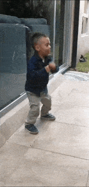 a young boy is dancing on a tiled floor in front of a couch
