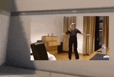 a woman is dancing in a room with a dresser and chairs