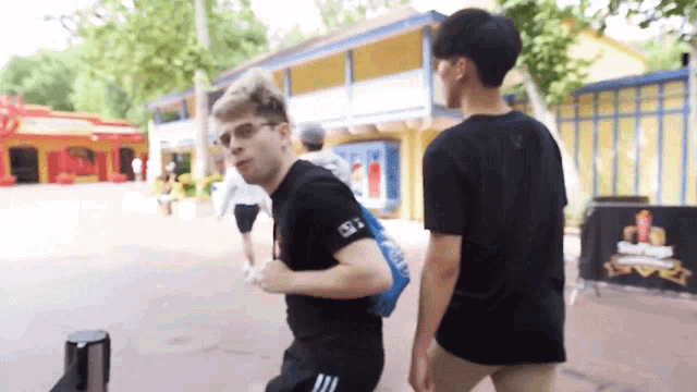 a man wearing a black shirt that says adidas on it