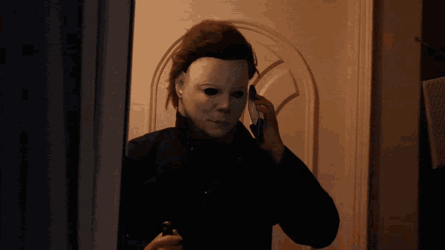 a person wearing a mask talking on a cell phone