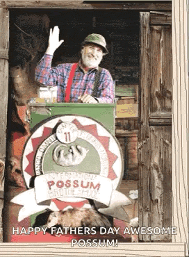 a man in a plaid shirt is standing in front of a train that says possum