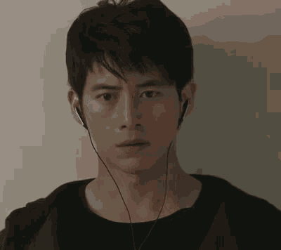 a close up of a man wearing headphones and looking at the camera .