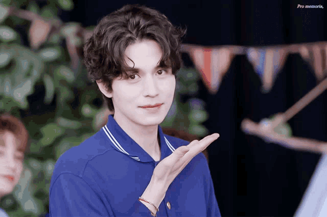 a man in a blue shirt is making a gesture with his hand and the words pro memoria are on the bottom