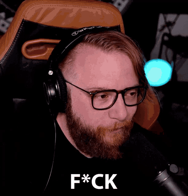 a man with a beard wearing headphones and glasses says f*ck