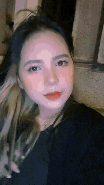 a close up of a woman 's face with a black shirt