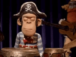 a monkey in a pirate hat is playing a drum