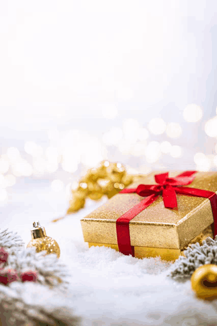 a gold gift box with a red ribbon