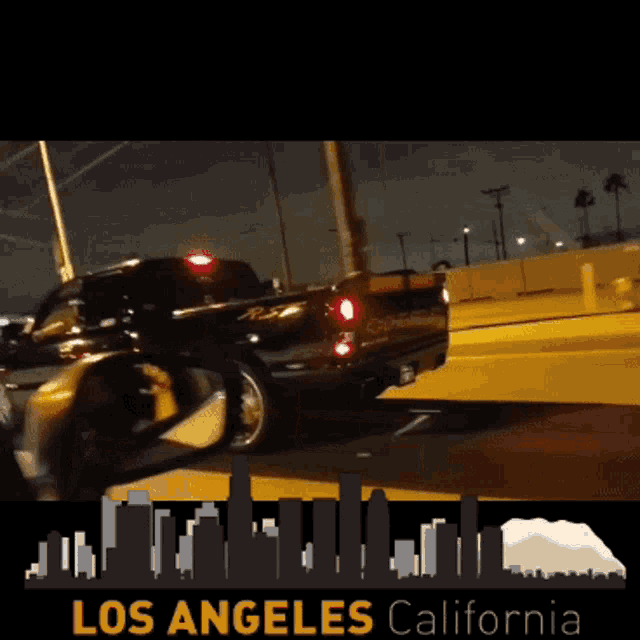 a black truck is driving down a street in los angeles