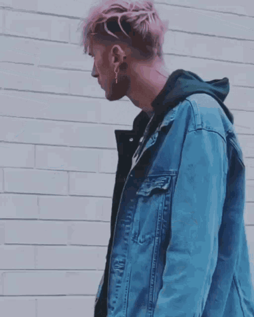 a man with pink hair wearing a denim jacket