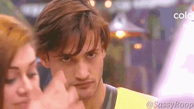 a man in a yellow shirt is making a funny face