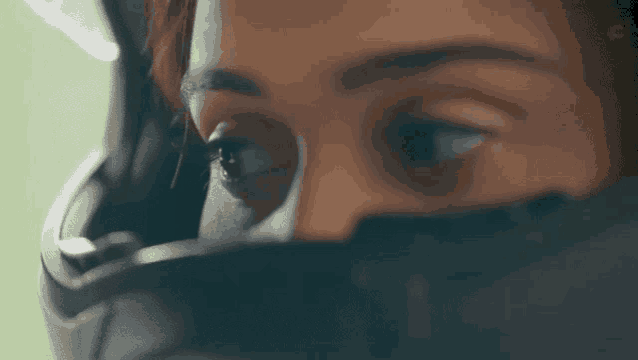 a close up of a woman 's face with a helmet on