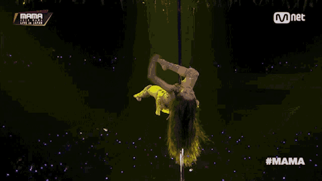 a pole dancer performs on a stage at the mama awards