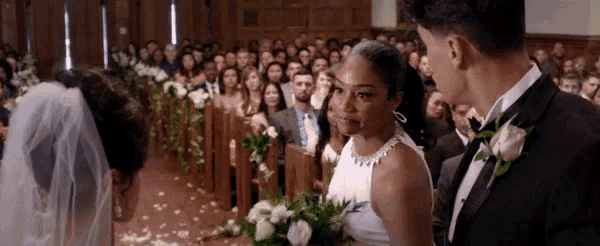 a bride and groom are walking down the aisle at their wedding in front of a crowd .