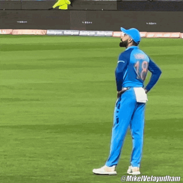 a man wearing a blue jersey with the number 18 on it