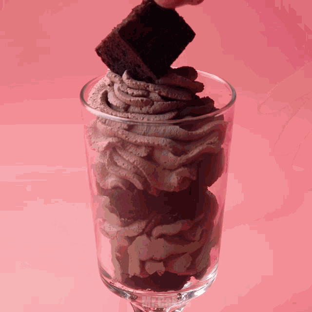 a chocolate brownie is being poured into a glass with mr.cakes written on it