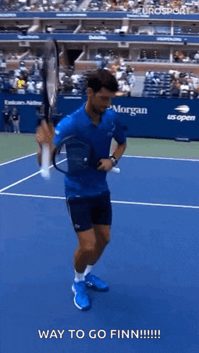 a man is holding a tennis racquet on a tennis court and saying `` way to go finn ! ''