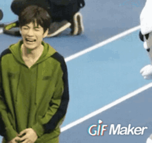 a man in a green hoodie is laughing next to a gif maker logo