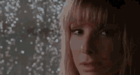 a close up of a woman 's face in front of a window with a blurry background