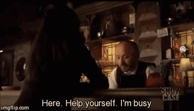 a man is talking to a woman at a bar and says help yourself i 'm busy