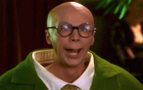 a bald man wearing glasses and a green sweater is making a funny face .