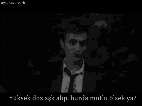 a black and white photo of a man in a suit and tie with the caption yüksek doz aşk alip burda mutlu olsek ya