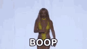britney spears is wearing a yellow swimsuit and dancing on a stage .