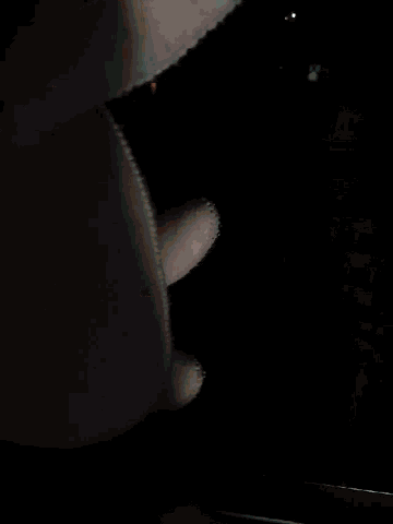 a person holding a stuffed animal in front of a dark window