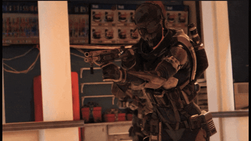 a man in a military uniform is holding a gun in front of a sign that says ' a ' on it