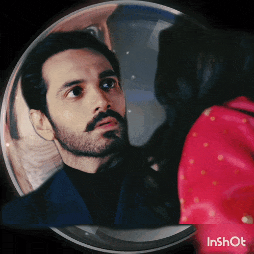 a man with a beard looks at a woman in a red dress