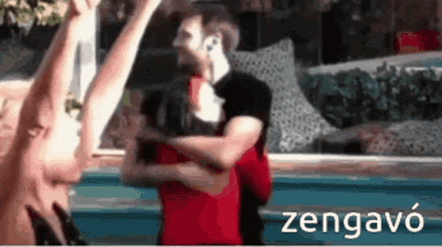 a man and a woman are hugging each other in front of a swimming pool .