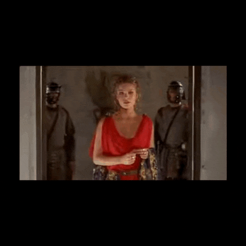 a woman in a red dress standing in front of a door