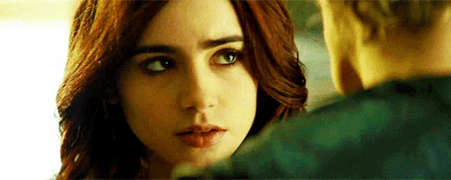 a close up of a woman looking at a man in a movie .