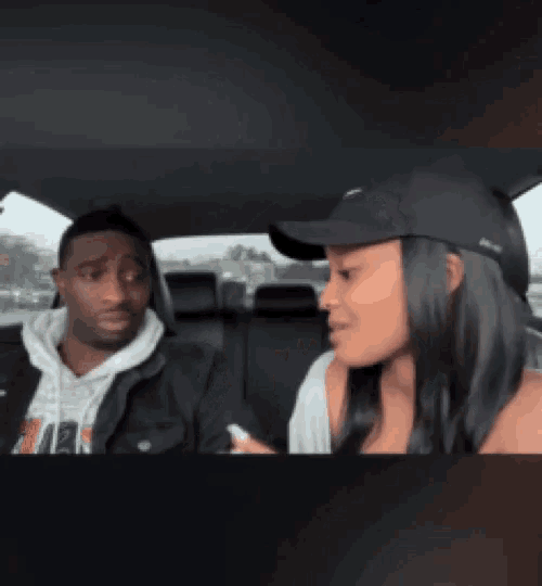 a man and a woman are sitting in a car