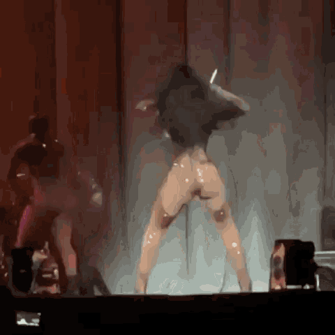 a woman is dancing on a stage in front of a crowd