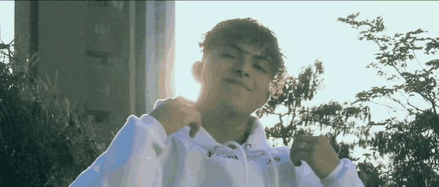 a young man wearing a white hoodie that says ' a ' on the front