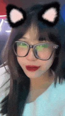 a young woman wearing glasses and cat ears is taking a selfie .