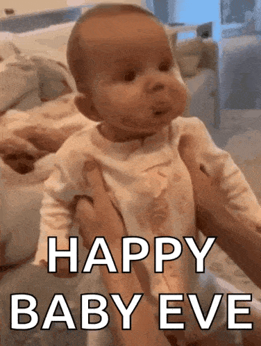 a baby is being held in a person 's arms with the words `` happy baby eve '' written on it .