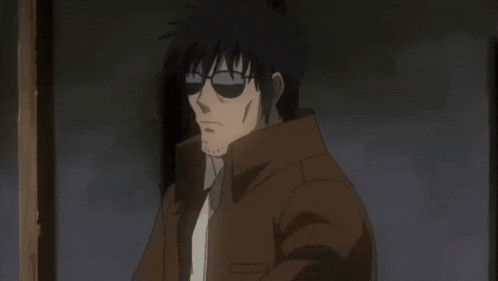 a man in sunglasses is holding a gun in a dark room with a light coming out of it .