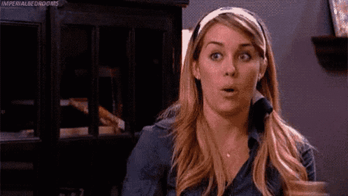 a woman with a surprised look on her face is wearing a headband and a blue shirt .