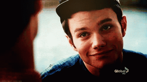 a young man wearing a baseball cap is smiling and looking at another man .
