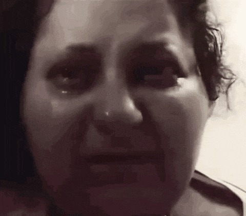 a close up of a woman 's face with a tear running down her cheek .