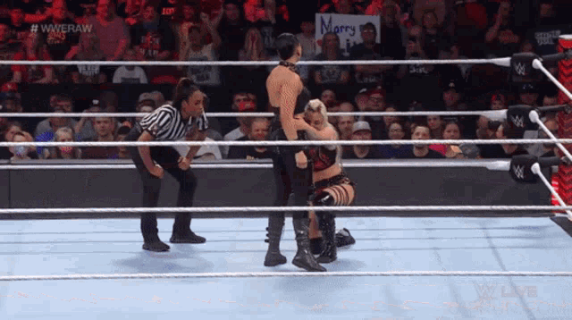 wrestlers in a wrestling ring with a sign that says marry