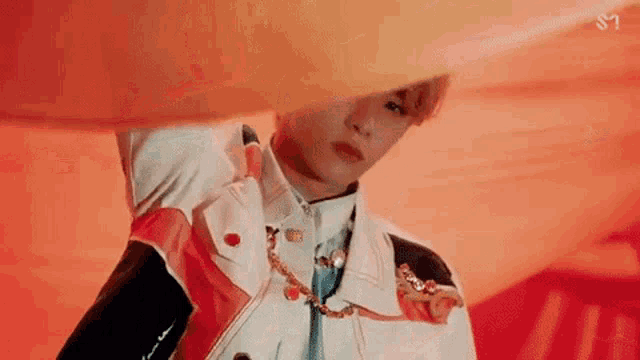 a close up of a person 's face with a red background and a white jacket .